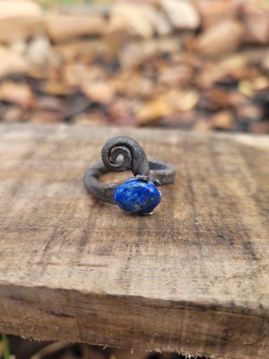 A hand forged ring made from an old nail and a lapis lazuli gemstone