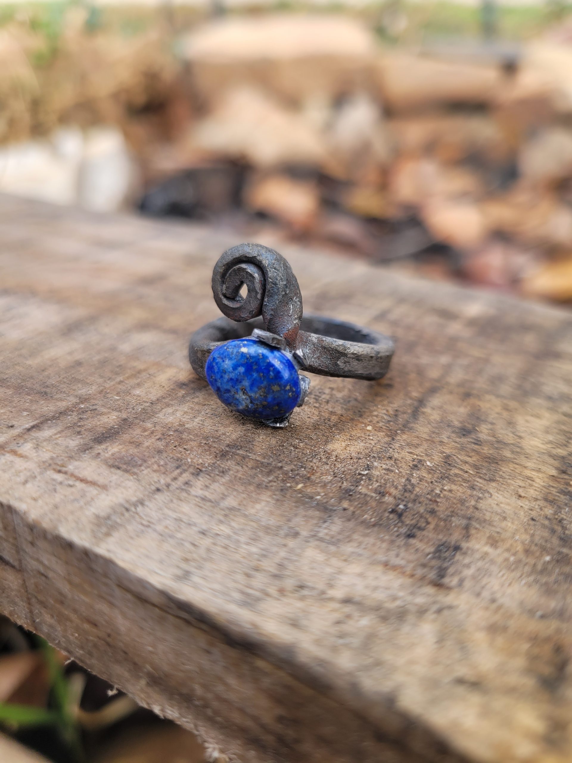 A hand forged ring made from an old nail and a lapis lazuli gemstone