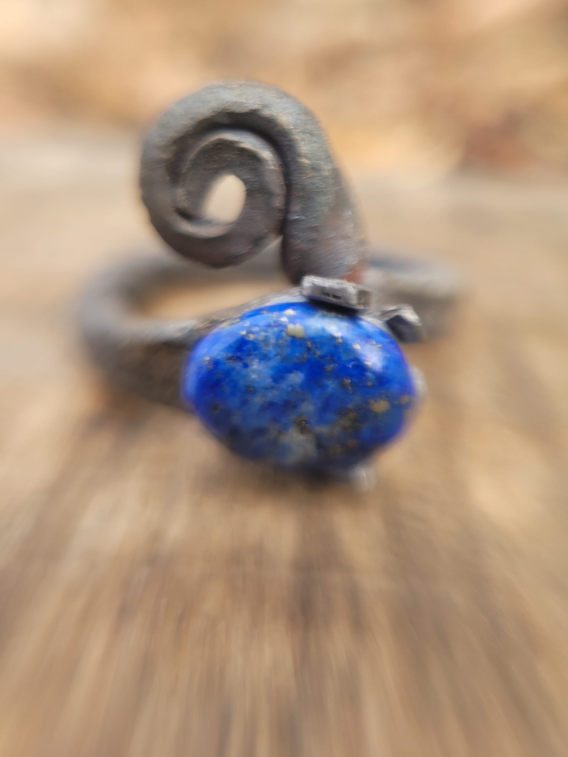 A hand forged ring made from an old nail and a lapis lazuli gemstone