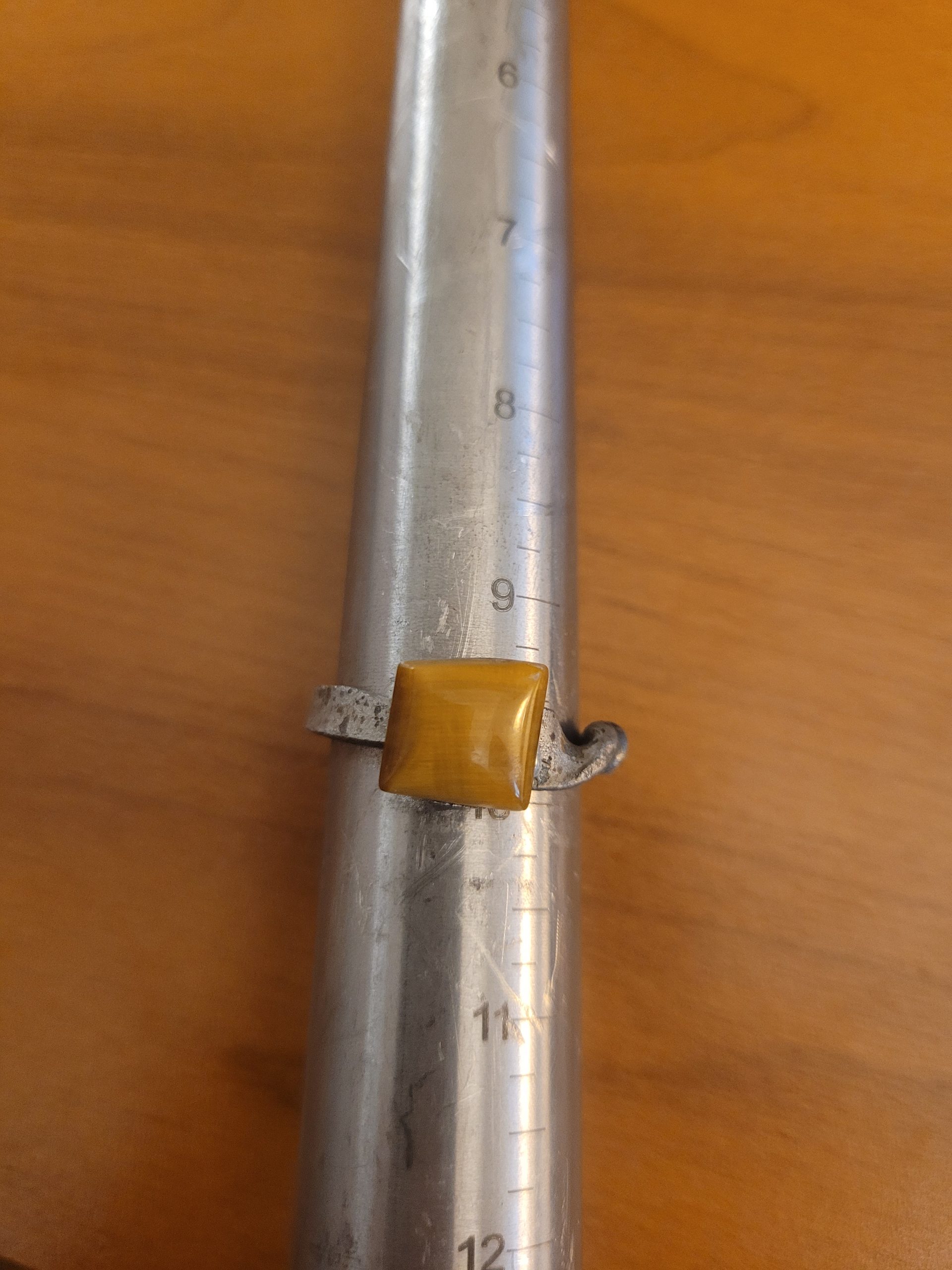 An alchemy inspired ring that was hand forged from an old nail. It is set with a square tiger's eye gemstone