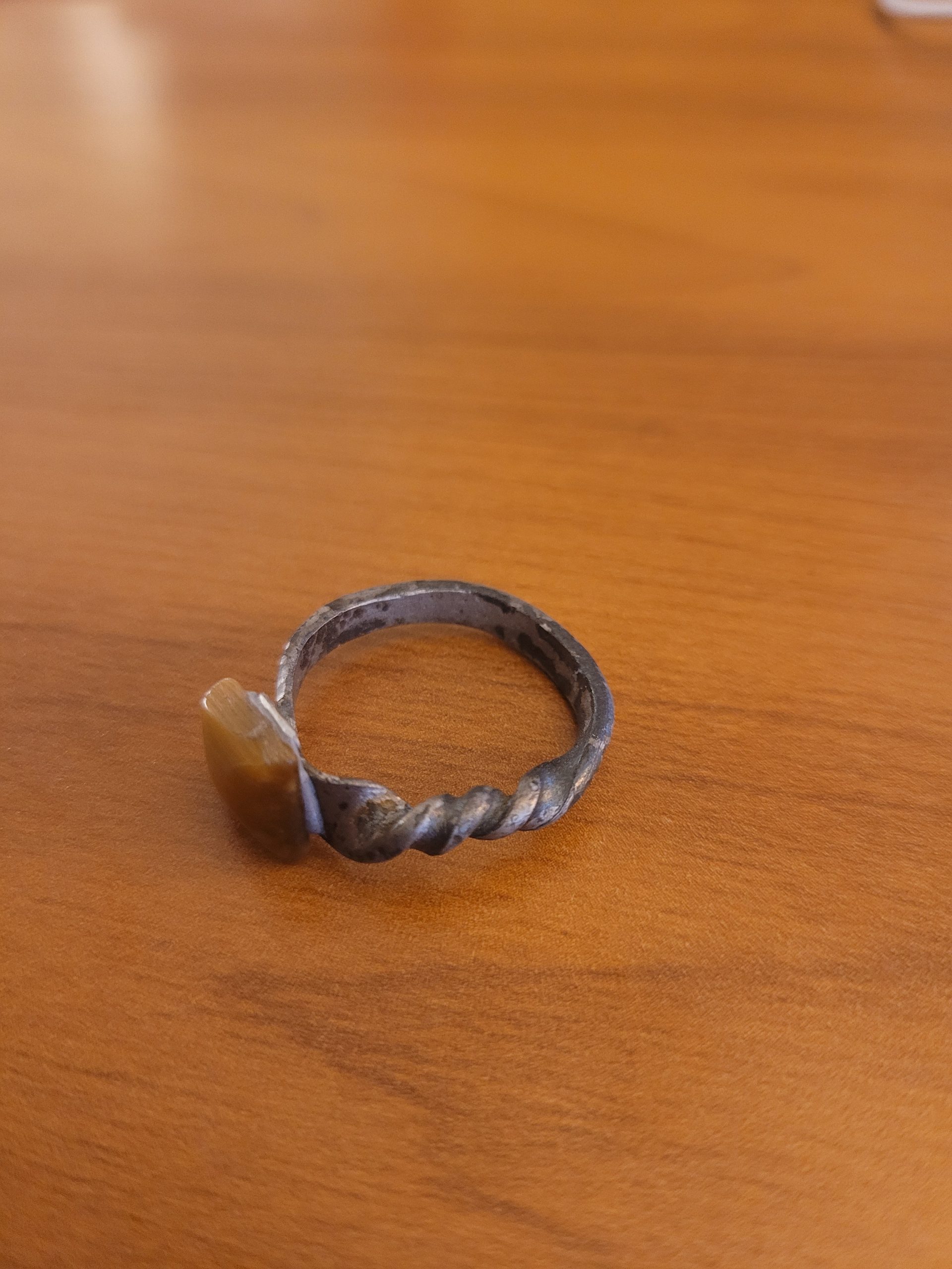 An alchemy inspired ring that was hand forged from an old nail. It is set with a square tiger's eye gemstone