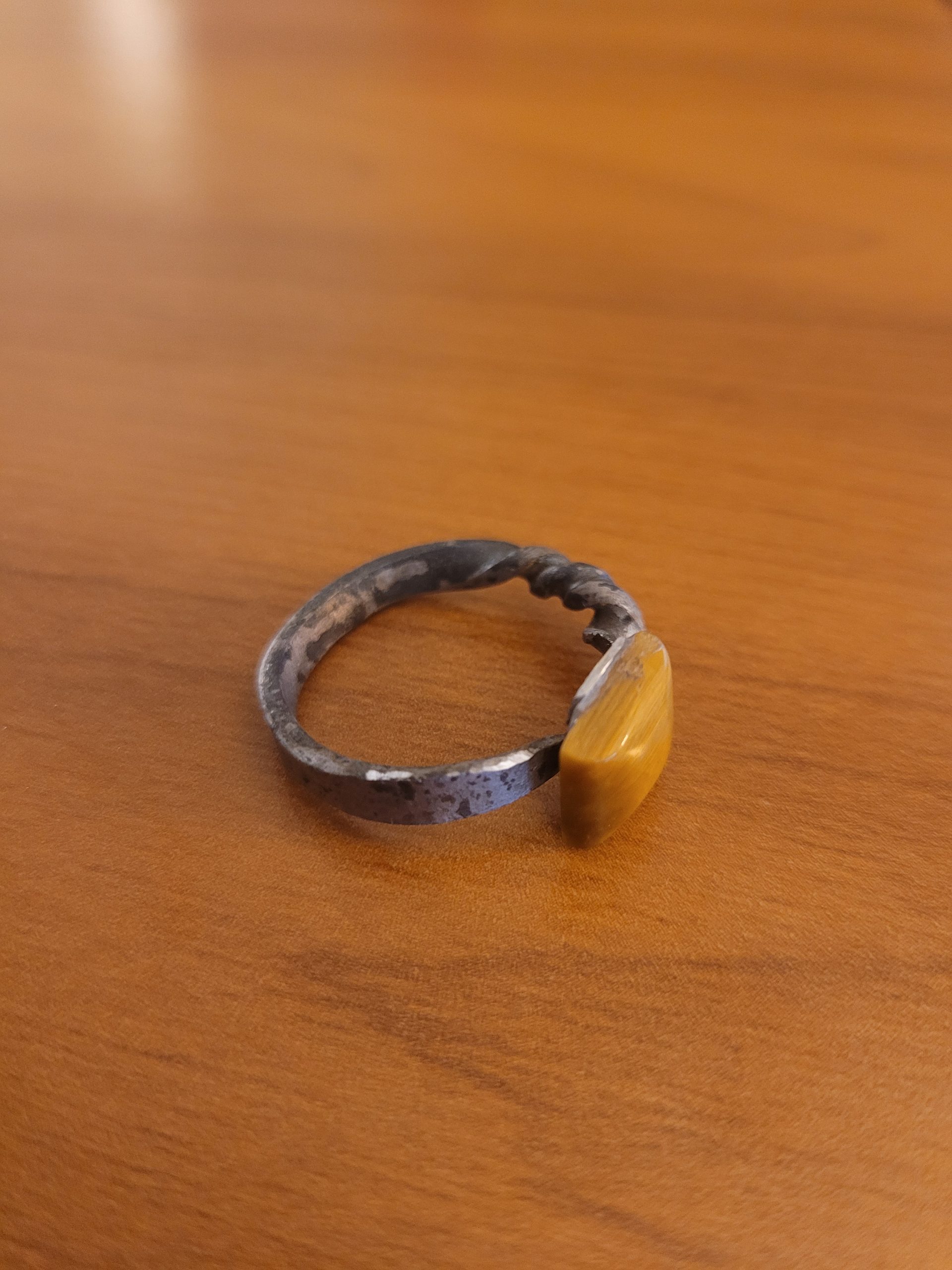 An alchemy inspired ring that was hand forged from an old nail. It is set with a square tiger's eye gemstone
