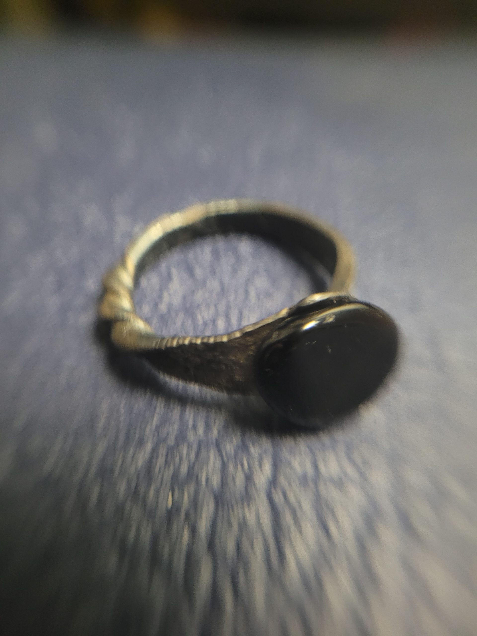 A handmade ring forged from an old nail. It is set with an obsidian stone that absorbs light