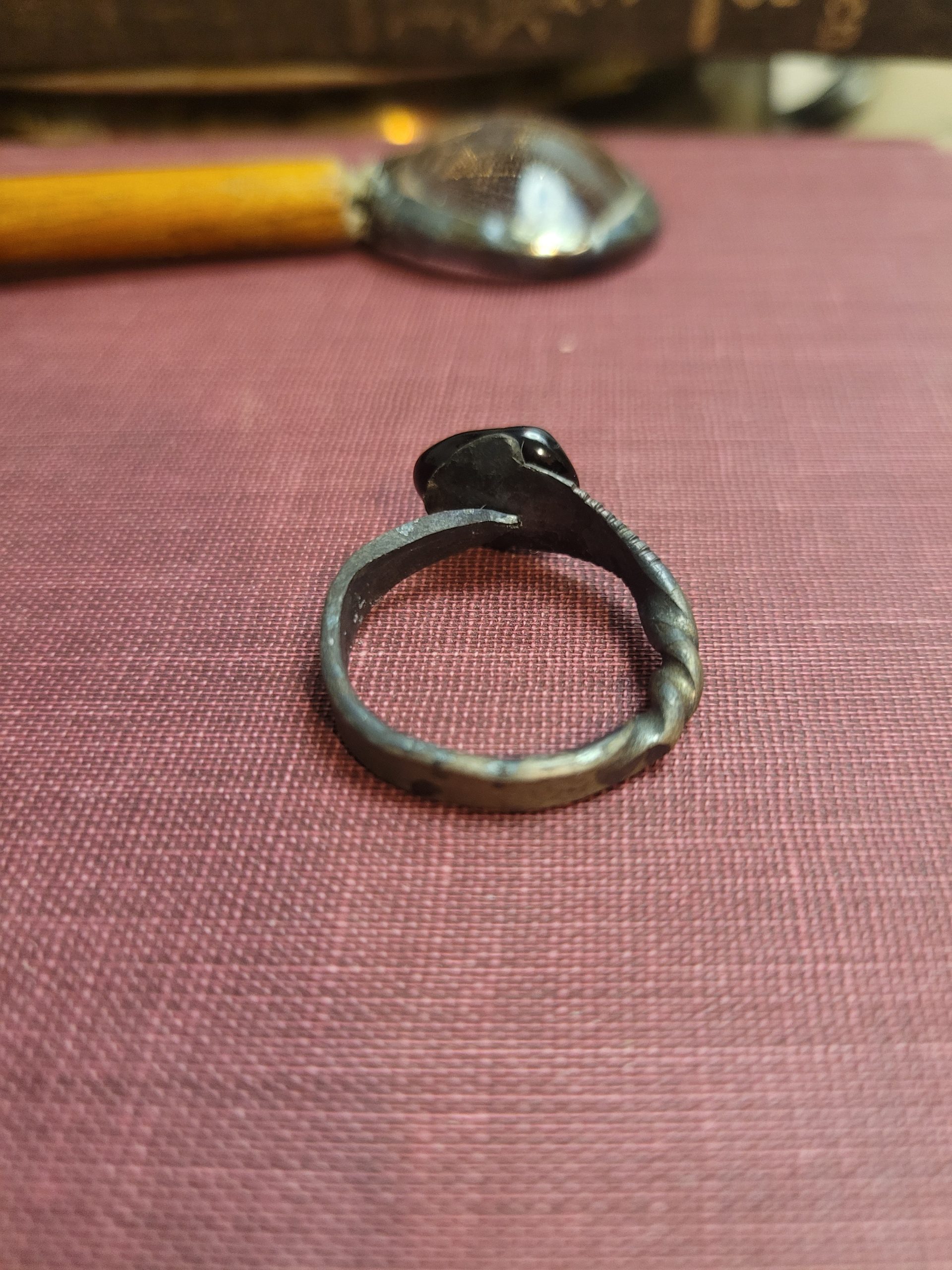 A handmade ring forged from an old nail. It is set with an obsidian stone that absorbs light