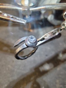 A hand forged ring made from an old nail, a bolt head, and set with clear quartz. Part of our handmade jewelry collection.